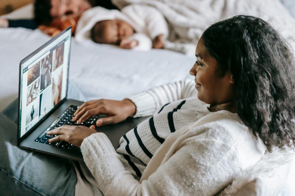 Mom of a highly sensitive child working on her laptop while her child sleeps in the background